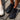 Two pairs of 8000Kicks Shifter shoes in white and black on a wooden deck outdoors.