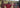 8000Kicks CEO outdoors with three members of a local Maasai community, surrounded by a rural landscape. Two people hold 8000Kicks T-shirts, while the CEO wears a beige 8000Kicks crossbody bag.