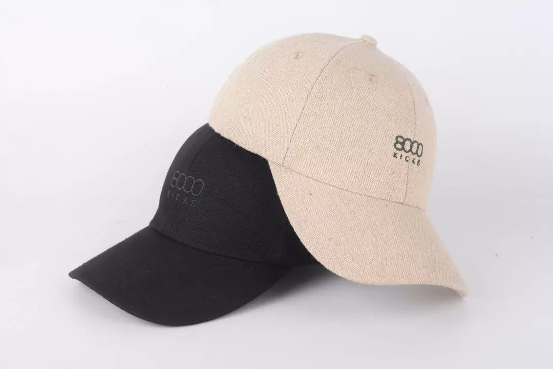 A black and beige hemp hat stacked on top of each other.